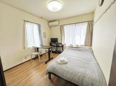 a bedroom with a bed and a desk in it at SHIBUYA HOUSE in Tokyo