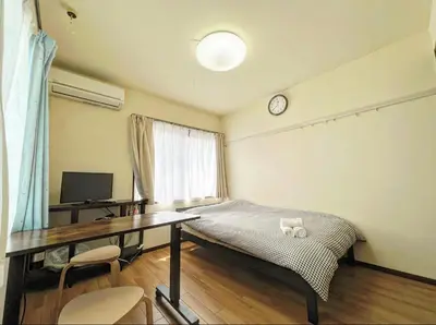 a bedroom with a desk and a bed and a table at SHIBUYA HOUSE in Tokyo