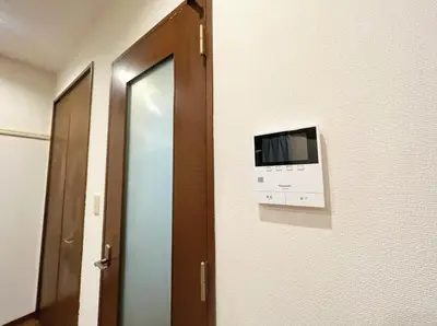 a room with a television on a wall with a door at SHIBUYA HOUSE in Tokyo