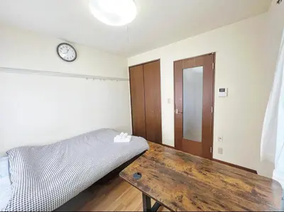 a bedroom with a wooden table and a clock on the wall at SHIBUYA HOUSE in Tokyo