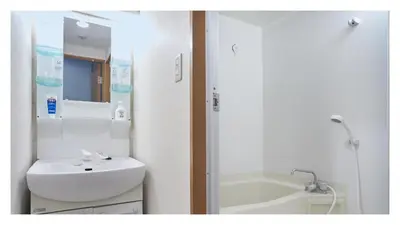 a white bathroom with a sink and a bath tub at Autumn Apartment Shinjuku in Tokyo