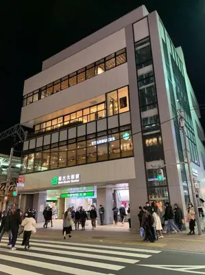 a group of people walking in front of a building at Autumn Apartment Shinjuku in Tokyo