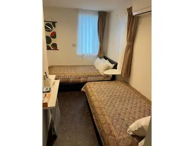 a room with two beds and a desk in it at Tokyo stay Hut SARI - Vacation STAY 27239v in Tokyo