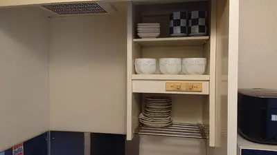 a cupboard with plates and bowls on a shelf at City Pal 
