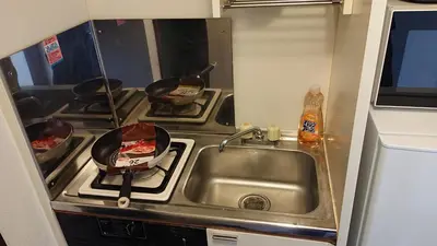 a kitchen with a sink and a stove with pans at City Pal 