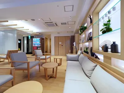 a waiting area in a hospital with chairs and tables at Far East Village Hotel Tokyo, Asakusa in Tokyo