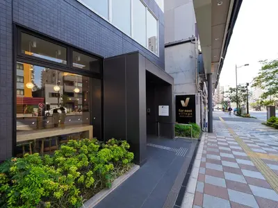 a building on a street with plants in front of it at Far East Village Hotel Tokyo, Asakusa in Tokyo