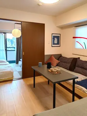 a living room with a table and a couch at ASAKUSA\u30fcHANAKAWADO in Tokyo