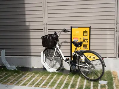 a bike parked next to a house with a basket at OTHER SPACE Asakusa in Tokyo