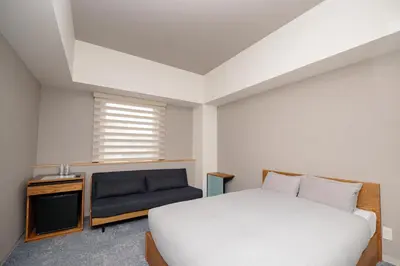 a bedroom with a white bed and a couch at OTHER SPACE Asakusa in Tokyo