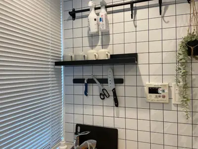 a white tiled wall with shelves with tools on it at Hotel Ougien in Tokyo
