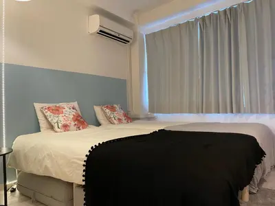 a bedroom with a bed with a black blanket on it at Hotel Ougien in Tokyo