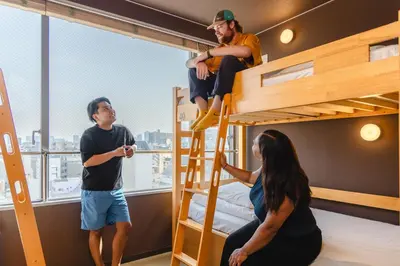 a group of people in a bunk bed room on a ship at COGO Ryogoku in Tokyo