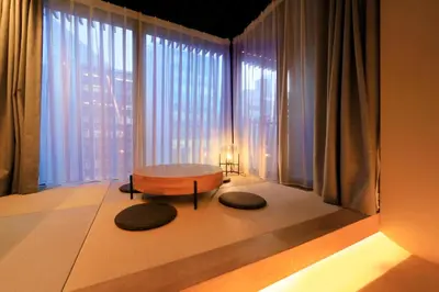 a living room with a table and large windows at Amanecer Hotel in Tokyo