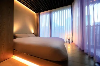 a bedroom with a white bed and a large window at Amanecer Hotel in Tokyo