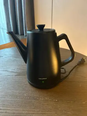 a black tea kettle sitting on a table at Amanecer Hotel in Tokyo