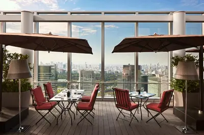 a restaurant with tables and chairs on a balcony at Bvlgari Hotel Tokyo in Tokyo