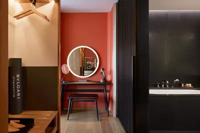 a bathroom with a mirror and a table with a stool at Bvlgari Hotel Tokyo in Tokyo