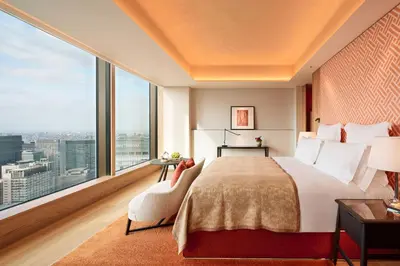 a bedroom with a large bed and a large window at Bvlgari Hotel Tokyo in Tokyo
