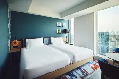 a bedroom with two beds and a large window at Hotel Indigo Tokyo Shibuya in Tokyo