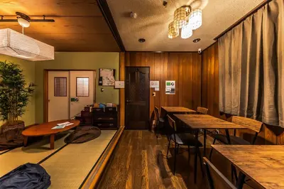 a dining room with tables and chairs and a table at Wabi Sabi Hostel in Tokyo