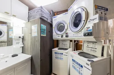 a laundry room with washing machines and a sink at Wabi Sabi Hostel in Tokyo