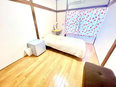 a small room with a bed and a window at Wabi Sabi Hostel in Tokyo