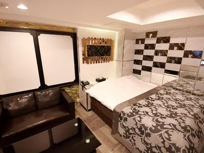 a bedroom with a bed and a chair in a room at HOTEL PARK SIDE in Tokyo