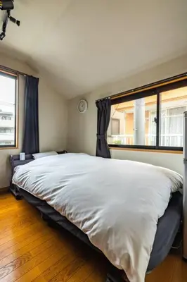 a bedroom with a large white bed with a window at \u30a2\u30f3\u30c9\u30b9\u30c6\u30a4\u897f\u65b0\u4e95 in Tokyo