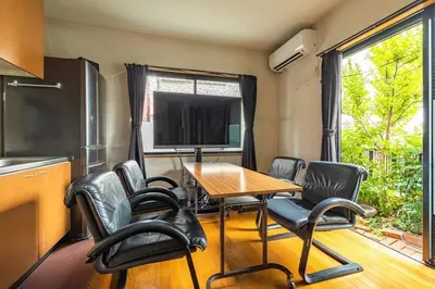a room with a table and chairs and a television at \u30a2\u30f3\u30c9\u30b9\u30c6\u30a4\u897f\u65b0\u4e95 in Tokyo