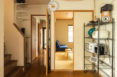 a hallway with a living room with a clock on the wall at \u30a2\u30f3\u30c9\u30b9\u30c6\u30a4\u897f\u65b0\u4e95 in Tokyo
