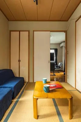 a living room with a bed and a coffee table at \u30a2\u30f3\u30c9\u30b9\u30c6\u30a4\u897f\u65b0\u4e95 in Tokyo