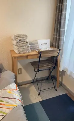 a desk in a room with a table with towels at Rize Apartments in Tokyo
