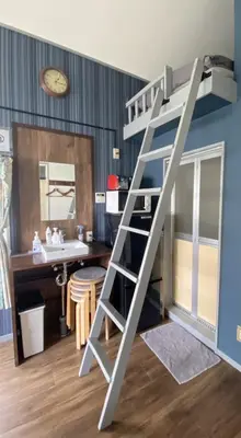 a bunk bed in a room with a desk and a ladder at Rize Apartments in Tokyo