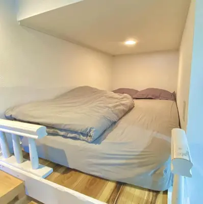a bed in a small room with a bed frame at Rize Apartments in Tokyo