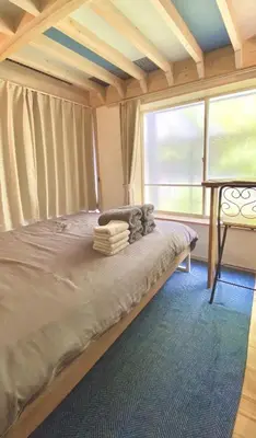 a large bed in a room with a large window at Rize Apartments in Tokyo