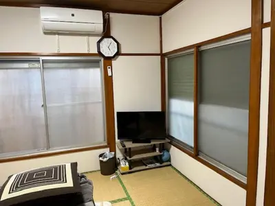 a room with two windows and a tv and a clock at D-pdal Inn 1F - Vacation STAY 14134 in Tokyo