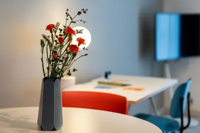 a vase with red flowers sitting on a table at Section L Residence Ginza in Tokyo