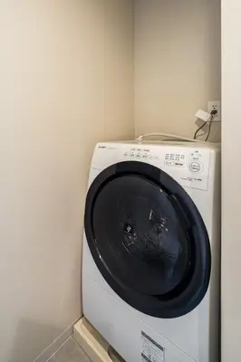 a washing machine in a corner of a room at Section L Residence Ginza in Tokyo