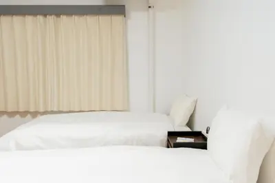 two beds sitting next to each other in a bedroom at Tokyo Skytree\u96fb\u8eca3\u5206 \u79cb\u8449\u539f\u307e\u30677\u5206 \u6d45\u8349\u6a4b\u307e\u30674\u5206 \u6d17\u9762\u53f0\u30b7\u30e3\u30ef\u30fc\u5ba4\u304c\u5225 \u30ad\u30c3\u30c1\u30f3\u5b8c\u5099 \u9326\u7cf8\u753a\u99c5 \u89b3\u5149\u5730\u30a2\u30af\u30bb\u30b9\u826f\u597d 303\u90e8\u5c4b in Tokyo