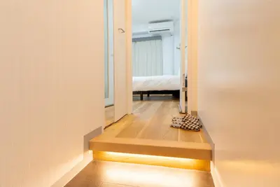 a hallway with a room with a bed at Tokyo Skytree\u96fb\u8eca3\u5206 \u79cb\u8449\u539f\u307e\u30677\u5206 \u6d45\u8349\u6a4b\u307e\u30674\u5206 \u6d17\u9762\u53f0\u30b7\u30e3\u30ef\u30fc\u5ba4\u304c\u5225 \u30ad\u30c3\u30c1\u30f3\u5b8c\u5099 \u9326\u7cf8\u753a\u99c5 \u89b3\u5149\u5730\u30a2\u30af\u30bb\u30b9\u826f\u597d 303\u90e8\u5c4b in Tokyo