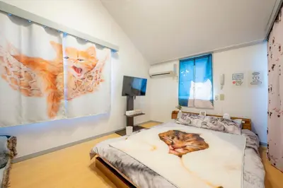 a bedroom with a bed with a cat on it at Tokyo Shibuya Shinjyuku Cat House ! in Tokyo