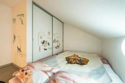 a bedroom with a bed with a painting of a wolf at Tokyo Shibuya Shinjyuku Cat House ! in Tokyo