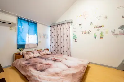 a bedroom with a large bed with a blanket on it at Tokyo Shibuya Shinjyuku Cat House ! in Tokyo