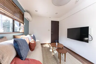a living room with a couch and a tv on a wall at LiveGRACE Hotel Shibuya \u6e0b\u8c37\u897f\u65b0\u5bbf in Tokyo