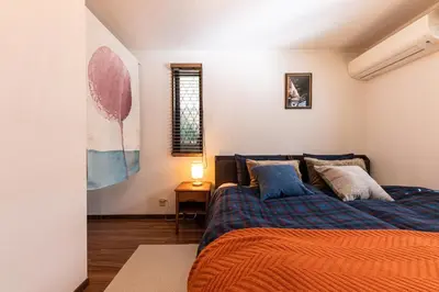 a bedroom with a bed with an orange blanket at LiveGRACE Hotel Shibuya \u6e0b\u8c37\u897f\u65b0\u5bbf in Tokyo