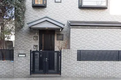 a brick house with a black door and a fence at LiveGRACE Hotel Shibuya \u6e0b\u8c37\u897f\u65b0\u5bbf in Tokyo