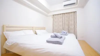 a bedroom with two beds with towels on them at TOKYO EXPERT SHINJUKU in Tokyo
