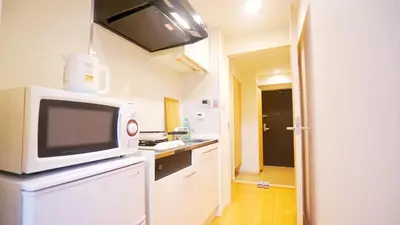 a kitchen with a microwave on top of a refrigerator at TOKYO EXPERT SHINJUKU in Tokyo