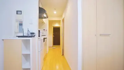 a kitchen with white cabinets and a yellow floor at TOKYO EXPERT SHINJUKU in Tokyo